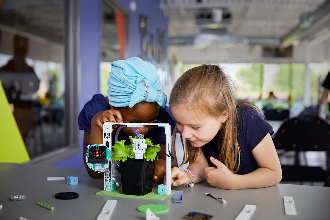 Two female students playing with the Smart Farming project from the Climate Action Kit