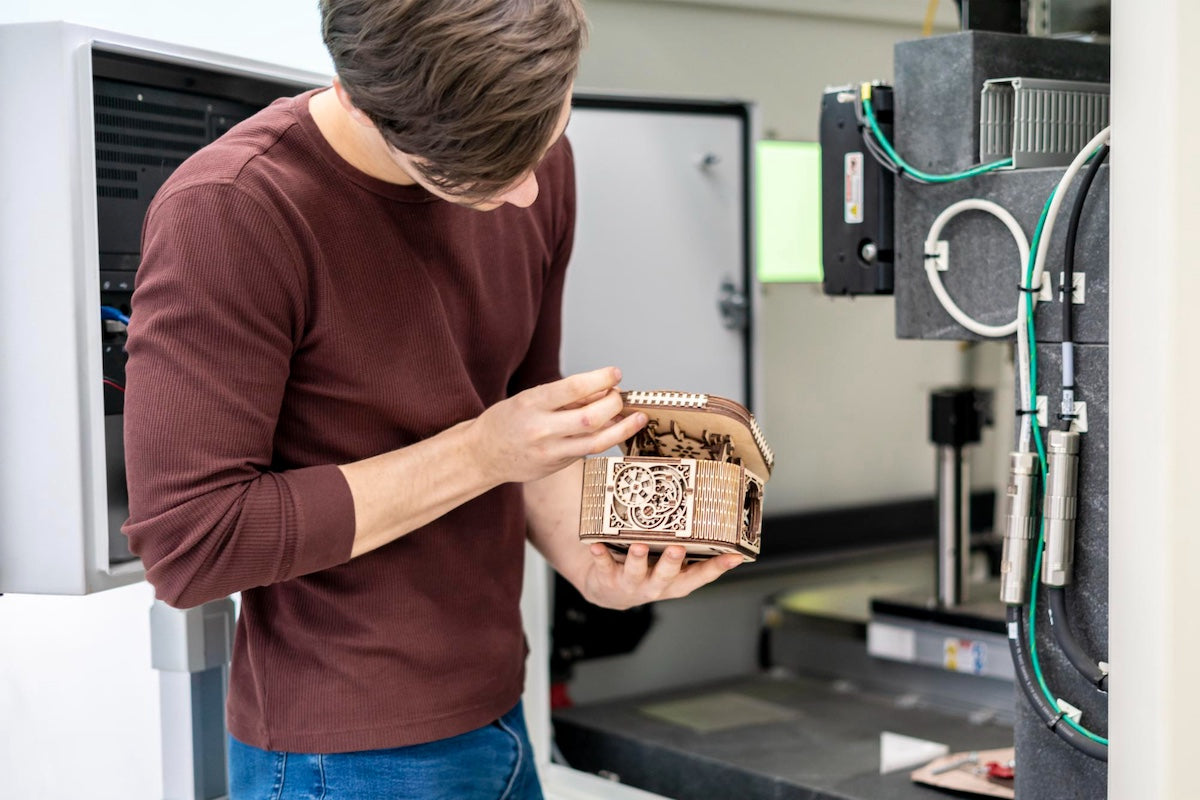 Male student looking at a laser cut decorative box