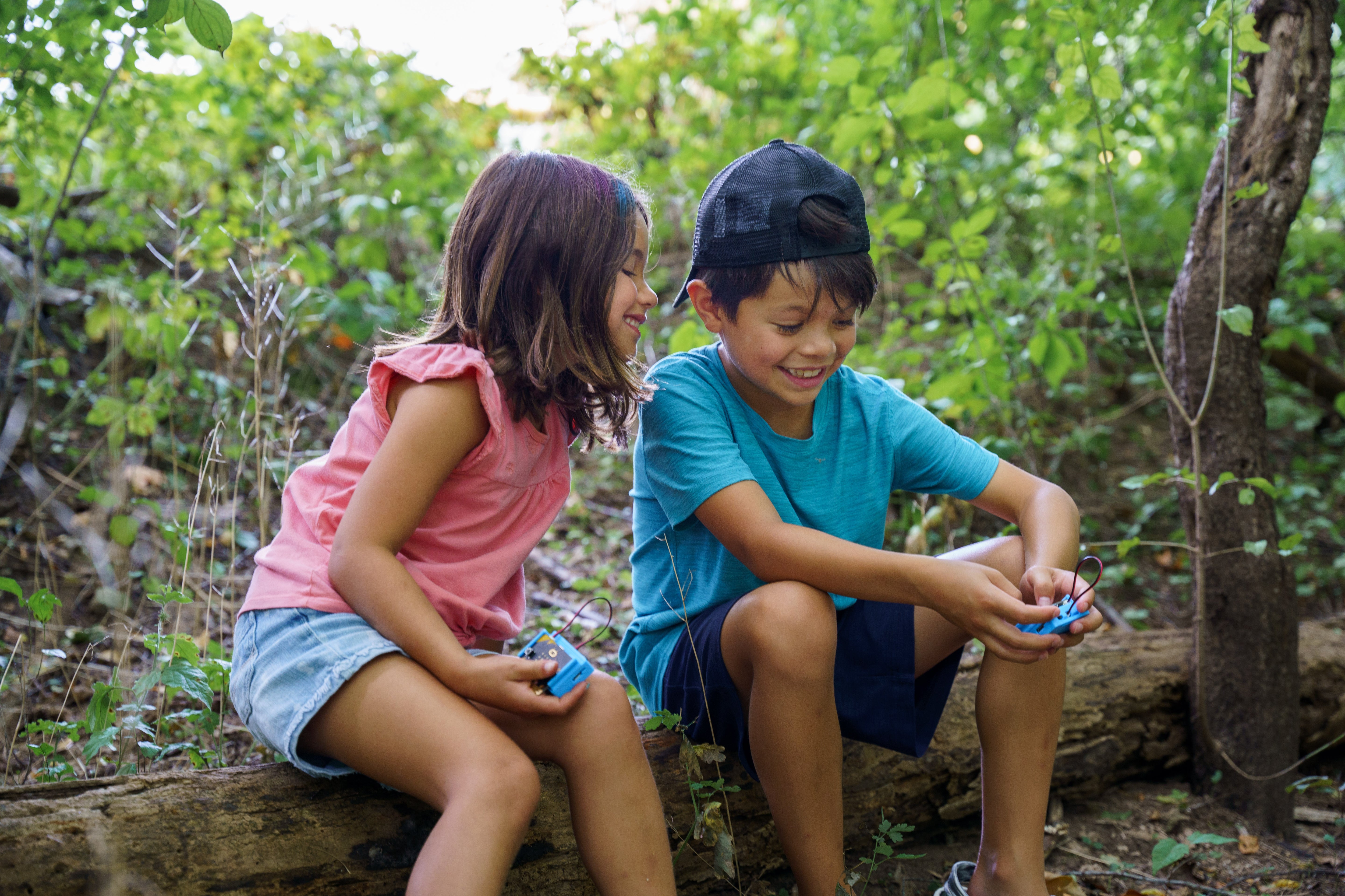 Two students using the CHARGE for micro:bit device outside